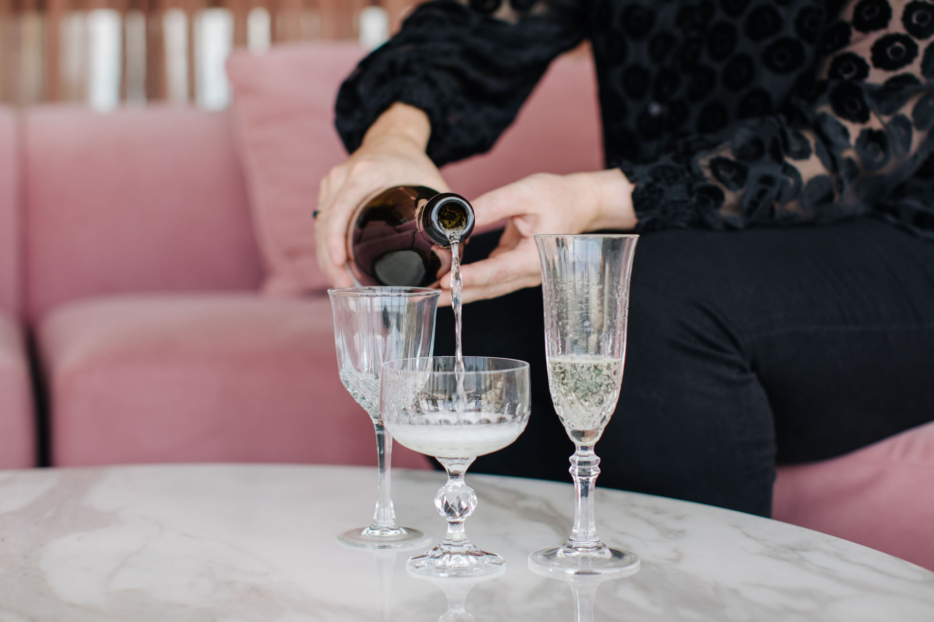 Emma Donnelly pouring sparkling wine into crystal glasses